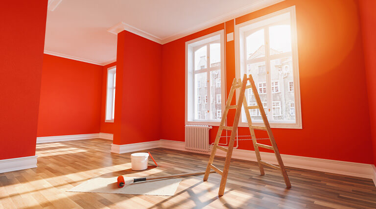 Streichen der Wand in Rot/Orange in einem Raum nach einer Restaurierung oder Renovierung